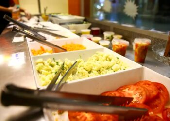 O buffet com opções de saladas frescas como tomate, cenoura, couve-flor, e outros ingredientes, ilustrando a variedade de alimentos que podem ser consumidos com o benefício do Vale Alimentação.