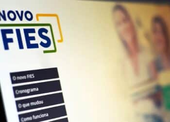 Tela de computador em foco com o logo "NOVO FIES", representando o portal Acesso Único para as inscrições de vagas remanescentes do Fundo de Financiamento Estudantil.