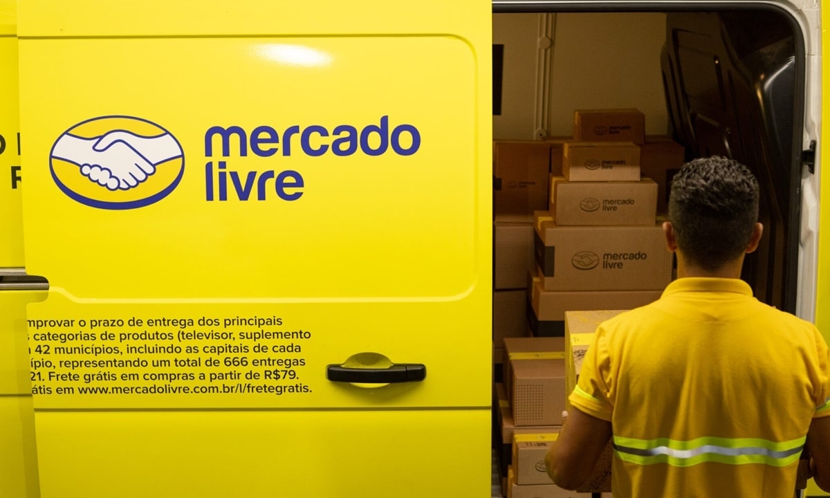 Funcionário do Mercado Livre carregando caixas em uma van amarela da empresa, simbolizando as 20 mil contratações e o reforço da equipe de Logística para a alta temporada.