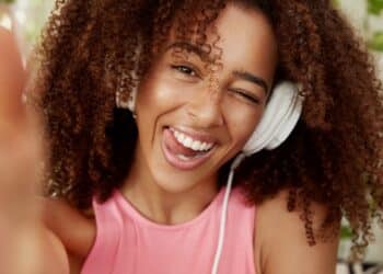 Jovem ouvindo música com fones de ouvido representando análise de títulos musicais.