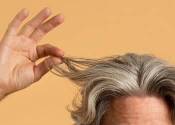 Pessoa mostrando cabelos grisalhos representando envelhecimento e proteção biológica natural