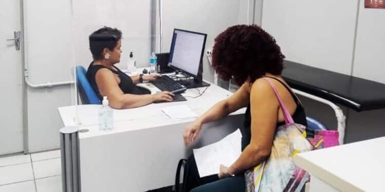 Atendimento presencial no INSS: beneficiária recebe orientações de servidora em balcão de serviço.