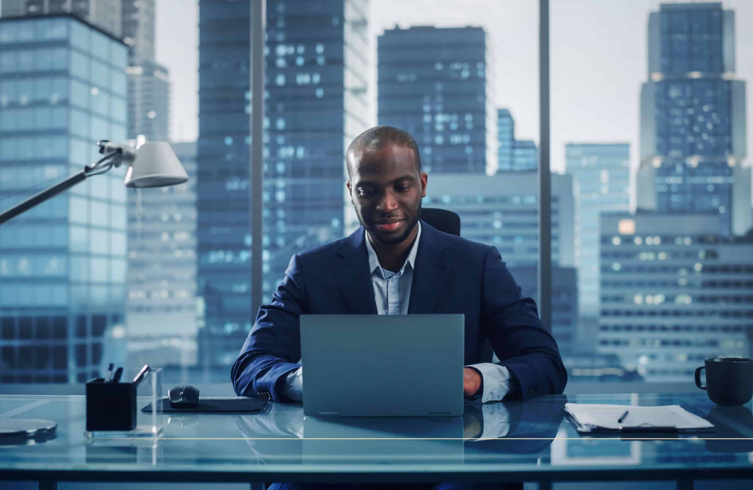 Administração. Executivo de administração trabalhando em notebook com vista para a metrópole, simbolizando liderança e visão estratégica em 2025.