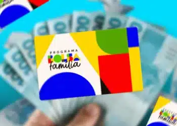 Cartão do programa Bolsa Família sobre cédulas de dinheiro, representando o pagamento do benefício em novembro.