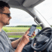 Motorista checando o celular com aplicativo de navegação, representando o trabalho com atividade remunerada.