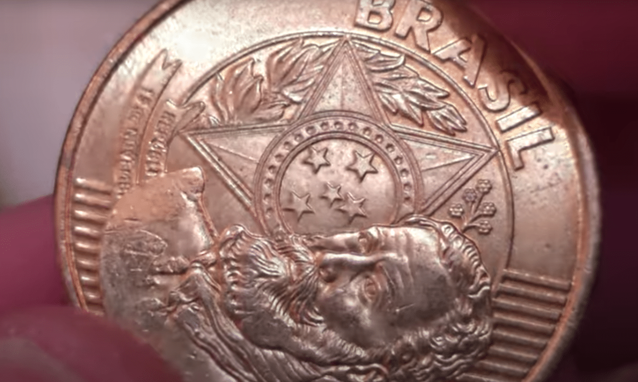 Close-up da moeda de 25 centavos destacando a efígie de Deodoro da Fonseca e a palavra "BRASIL", fundamental para identificar o reverso rotacionado (erro de cunhagem) que a torna rara.