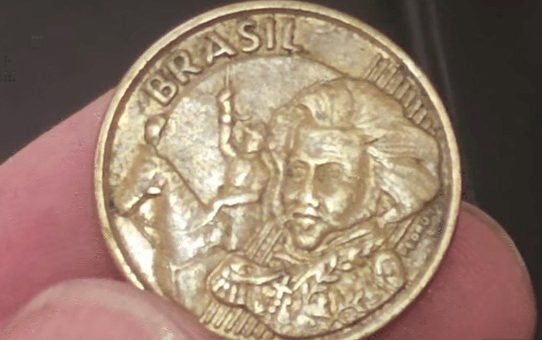 Anverso da moeda de 10 centavos (Dom Pedro I e cavalo) com falha sutil de cunhagem (conhecida como "penacho na cabeça do cavalo"), indicando o raro e procurado erro de produção que multiplica o valor numismático da peça de 2009.