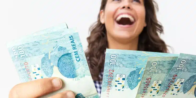 Mulher sorrindo e segurando notas de 100 reais, com destaque para a sensação de felicidade por receber um pagamento extra.