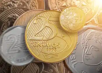 Moedas de 25 centavos e outras moedas em fundo desfocado com efeito de luz