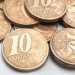 Pilha de moedas de 10 centavos do Brasil, algumas com as datas 2008, 2010 e 2016 visíveis, indicando a possibilidade de moedas raras.