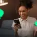 Mulher negra sorridente olhando para o celular, segurando um cartão, com a interface do Banco do Brasil e o símbolo do Pix ao fundo, ilustrando a agilidade do novo método de pagamento por foto via WhatsApp.