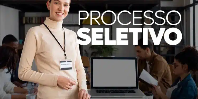 Mulher sorridente com crachá de consultora ao lado de laptop em sala de reunião durante processo seletivo