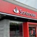 Imagem de uma agência do Santander, destacando a fachada moderna, com o logo e o convite para novas oportunidades de trabalho. Vagas abertas até 15 de outubro.