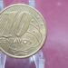 Reverso em close-up da moeda brasileira de 10 centavos de 2009, destacando o valor facial, o ano e as linhas em diagonal, essencial para identificar possíveis erros de cunhagem raros, como o 'cunho quebrado' ou 'reverso horizontal', que a tornam valiosa.