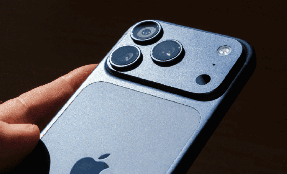 Operadoras lançam ofertas de iPhone com descontos de até 70% antes da Black Friday Pessoa segurando um iPhone azul, destacando as câmeras traseiras do aparelho.