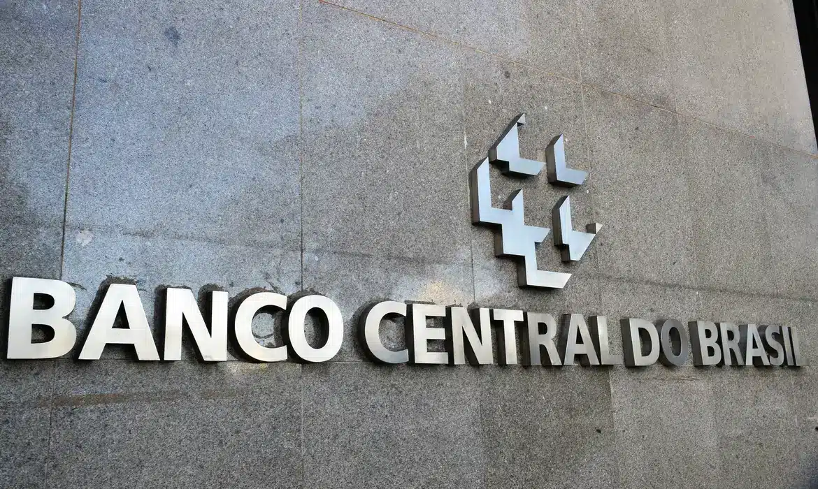 Logo do Banco Central do Brasil na fachada de um edifício, com destaque para os valores disponíveis para resgate no Sistema Valores a Receber.