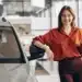 Mulher sorrindo com chave de carro usada em concessionária, destacando a importância de cuidados ao comprar carro usado de 2022.