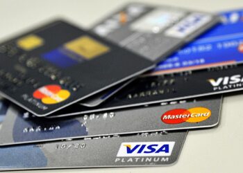 Pilha de cartões de crédito Visa Platinum e MasterCard Platinum em superfície branca