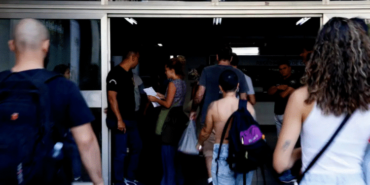 cnu Pessoas jovens entrando em prédio com mochilas nas costas e documentos na mão, ambiente de universidade