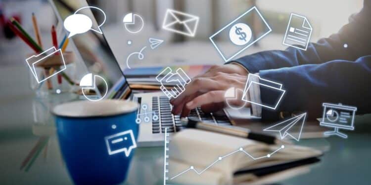 Pessoa trabalhando em um notebook com diversos ícones digitais e de negócios (mensagens, e-mail, dinheiro, gráficos) flutuando ao redor, representando as mudanças e inovações nas profissões de Saúde, Logística e Marketing Digital.