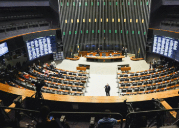 Plenário vazio da Câmara dos Deputados com cadeiras dispostas e painéis eletrônicos ao fundo