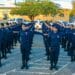 Grupo de guardas municipais em uniforme azul marinho alinhados em formação durante treinamento ao ar livre