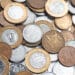 Variedade de moedas brasileiras do Plano Real, com exemplares de 1 Real e centavos, sugerindo a possibilidade de encontrar peças raras com alto valor escondidas no troco.