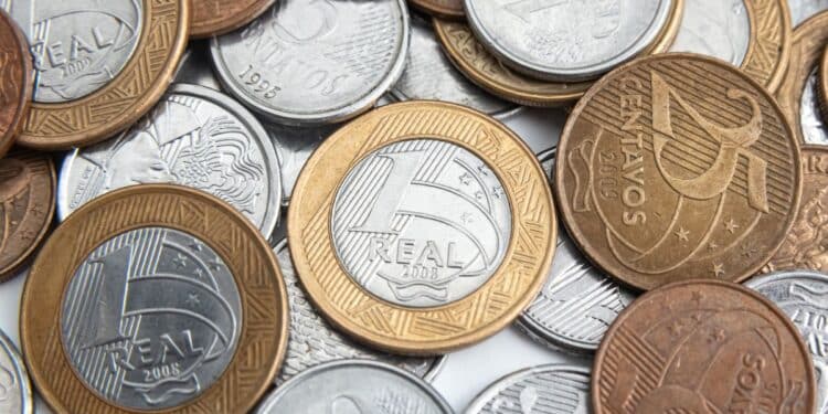 Amontoado de moedas do Plano Real, incluindo peças de 1 Real, 50, 25 e 10 centavos, ilustrando o troco do dia a dia que pode esconder moedas raras devido ao erro de alinhamento reverso.