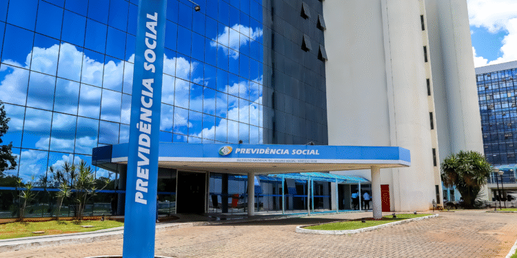 Edifício sede do INSS com fachada em vidro espelhado e placa azul com o nome Previdência Social
