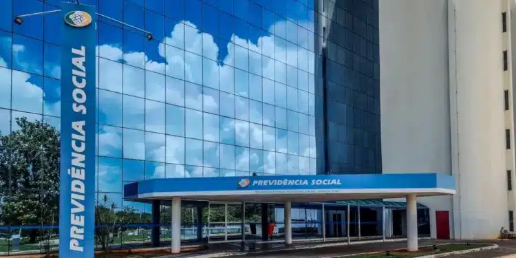 Fachada do INSS com céu refletido na parede de vidro, representando o atendimento do INSS em mutirão.