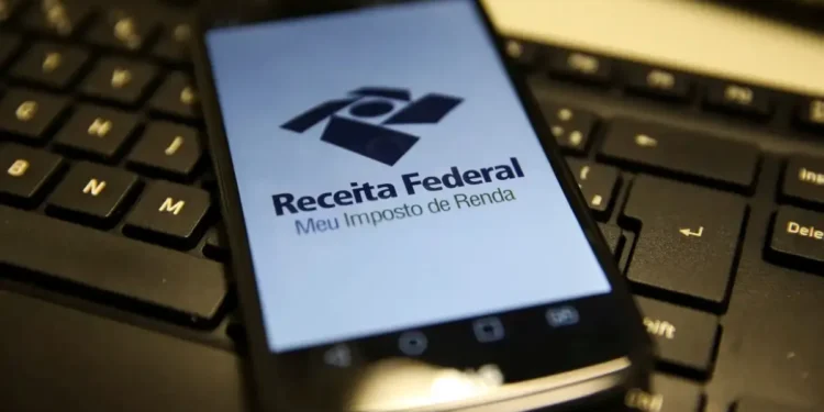 Imagem mostrando o logo da Receita Federal em um smartphone com foco no aplicativo Meu Imposto de Renda.
