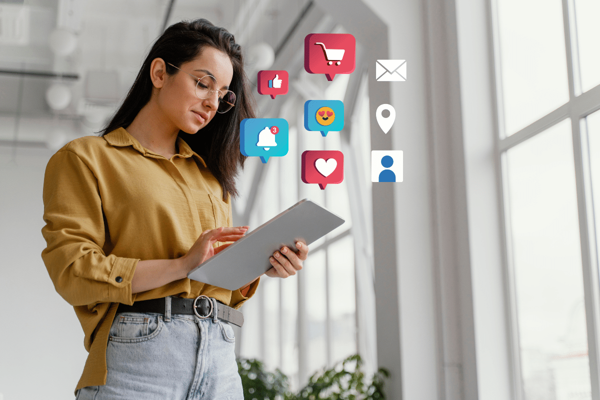 marketing digital Mulher de óculos usando tablet com ícones de redes sociais como carrinho, like e notificações ao redor