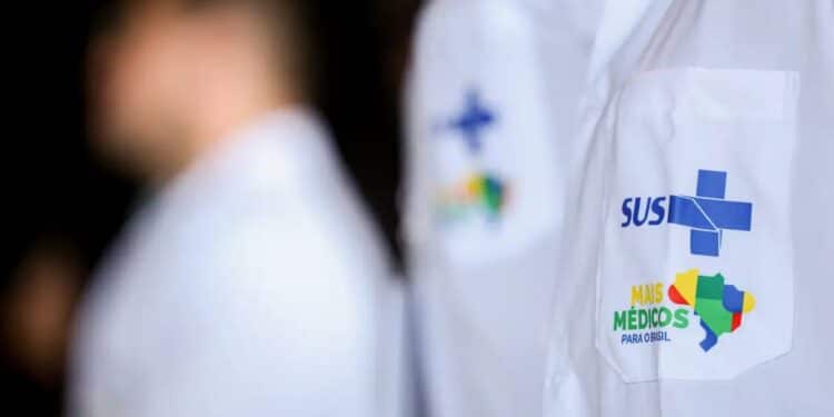 Médicos com jaleco do SUS, representando o programa Mais Médicos para o Brasil, enquanto o Enamed 2025 é realizado.
