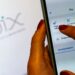 Mãos usando um celular com a interface do Pix, focando nas opções de pagamento e transferência. Ilustra a modalidade Pix Parcelado aguardando regras finais do Banco Central.