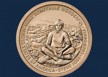 Moeda comemorativa ou medalha com o retrato de Steve Jobs em meditação e a inscrição "STEVE JOBS - CALIFORNIA", representando a homenagem póstuma que o transformou em rosto de uma moeda americana.