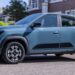 Renault Kwid E-Tech 2026 em movimento, destacando seu design moderno e minimalista.
