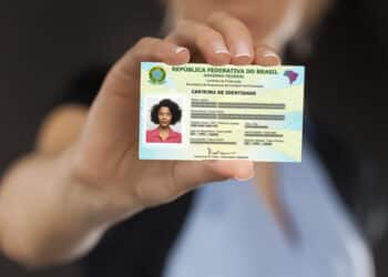 Imagem de uma pessoa segurando uma carteira de identidade brasileira.