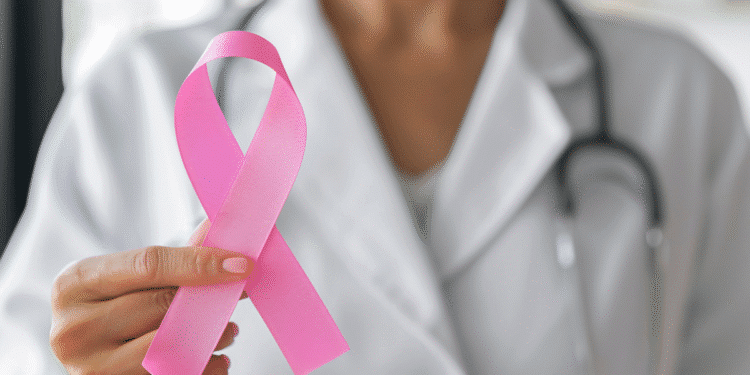 Médico segurando fita rosa representando a campanha de conscientização do câncer de mama