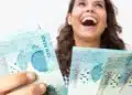 Pessoa segurando cédulas de dinheiro, representando o saque do FGTS por calamidade no valor de até R$ 6.220.