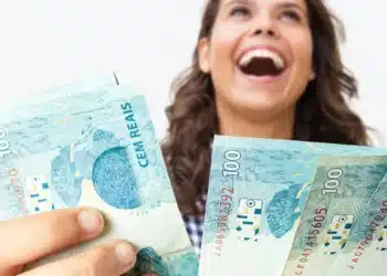Pessoa segurando cédulas de dinheiro, representando o saque do FGTS por calamidade no valor de até R$ 6.220.