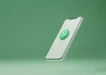 Imagem de celular com logo do WhatsApp flutuando, representando limpeza e otimização de apps no smartphone.