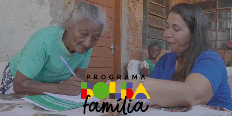 Idosa e assistente do CRAS realizando cadastro para o Bolsa Família em ambiente comunitário.