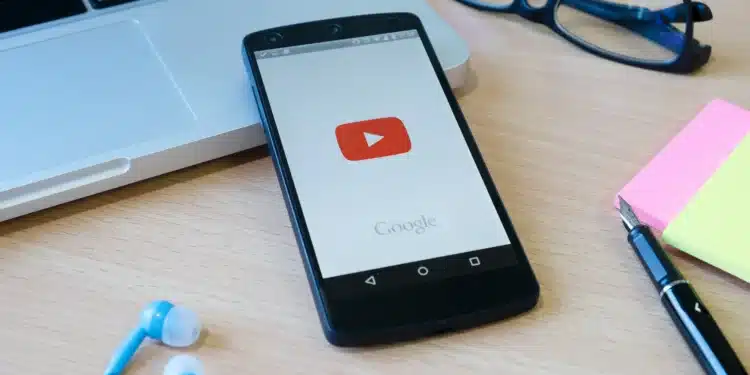 Celular com app do YouTube aberto mostrando a interface inicial, com o ícone do YouTube destacado.
