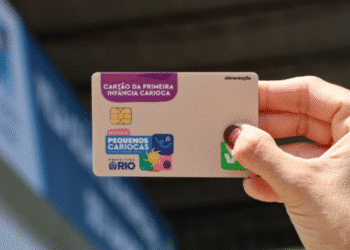 Pessoa segurando o Cartão da Primeira Infância Carioca do programa Pequenos Cariocas, benefício de alimentação da Prefeitura do Rio.