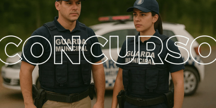 Dois agentes da Guarda Municipal uniformizados em frente a uma viatura.