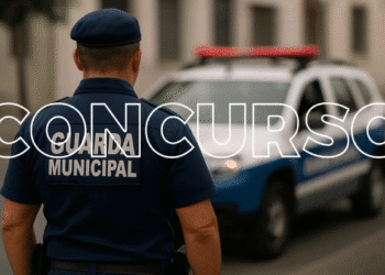 Guarda municipal de costas, vestindo uniforme azul e boné, ao lado de viatura policial branca com luzes vermelhas acesas, em rua urbana com edifícios ao fundo, e texto promocional "CONCURSO GUARDA MUNICIPAL".