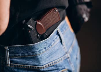 Arma de fogo em coldre policial na cintura representando equipamento da Polícia Civil