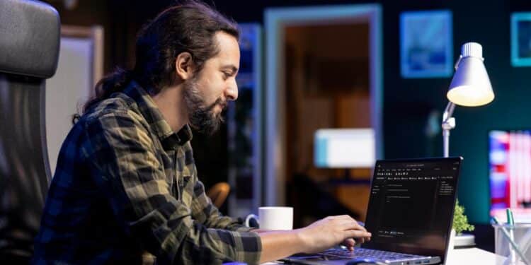 Desenvolvedor trabalhando remotamente em laptop à noite representando profissão com horário flexível sem jornada fixa