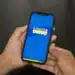 Pessoa segurando celular com a tela do aplicativo Cadastro Único aberta