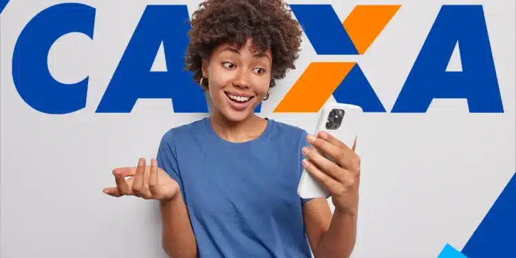 Mulher sorrindo enquanto olha para o celular com logo da CAIXA ao fundo.